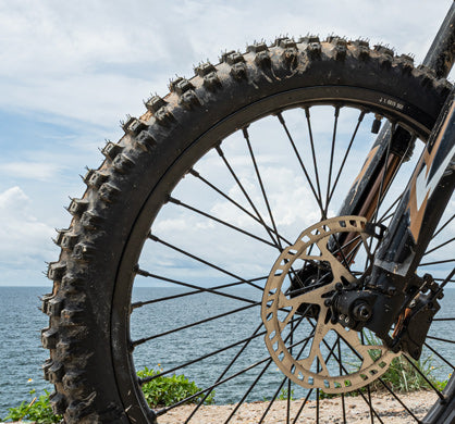 Front tire with durable knobby tread for excellent grip and puncture resistance on rugged trails and diverse surfaces.