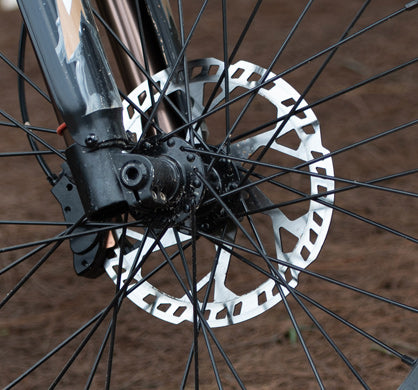 Close-up of a bicycle disc brake rotor mounted on a wheel with spokes
