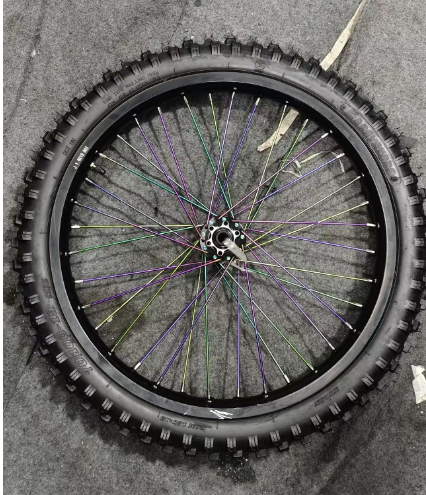 Front Tire for GT73 with colorful spokes on gray surface.