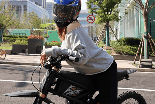 The image shows a female rider wearing a helmet on an electric bike, emphasizing the importance of safety in the eBike Safety & Legal Guide