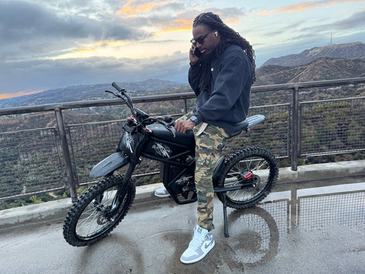 A man sitting on the Riding Time GT73 electric bike, showcasing its sleek design and advanced features.