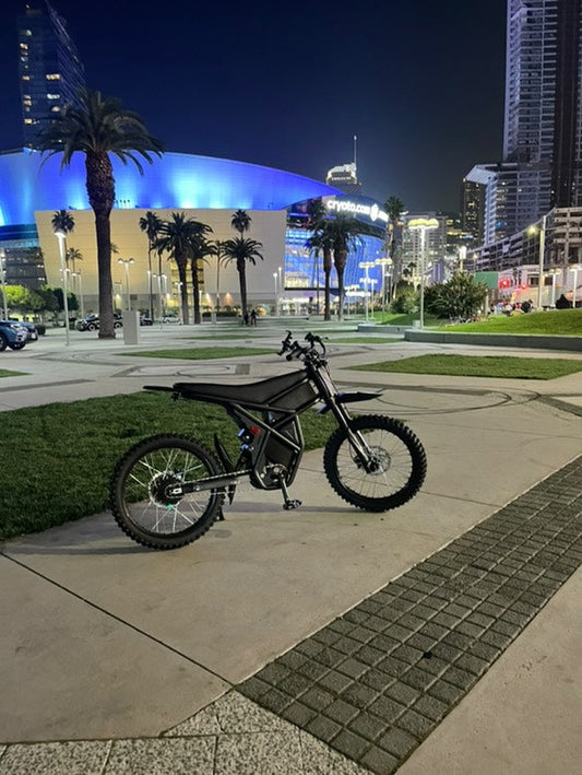 High-end electric bike parked in urban cityscape at night, showcasing urban e-commute solutions.