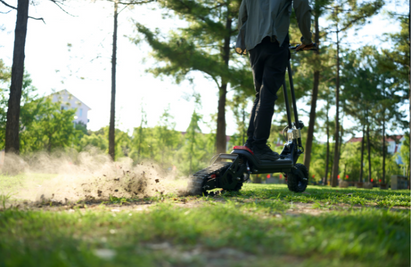 G63 Convertible Electric Scooter in off-road mode, traversing grassy terrain.